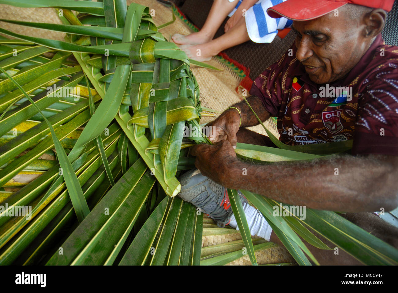 Fijian man creates a basket from weaving a Coconut Palm leaves, Pacific