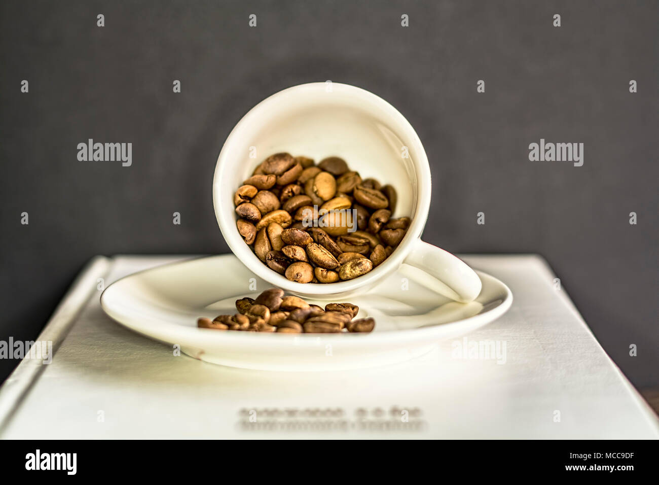 Coffee cup with coffee beans in it on black background. Still life closeup shot. Stock Photo