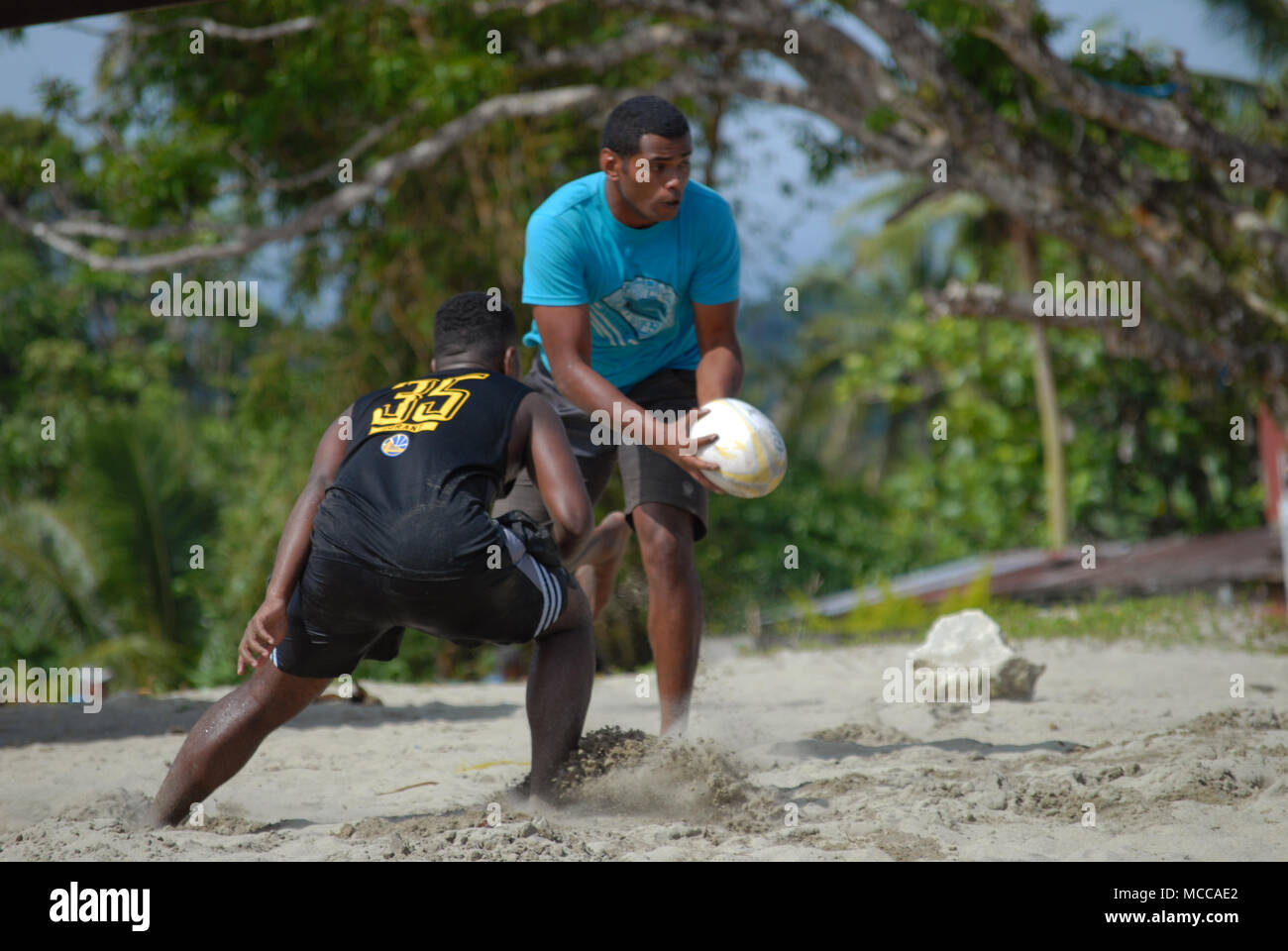 Fijian men playing rugby on Palm Beach, Pacific Harbour, Fiji Stock