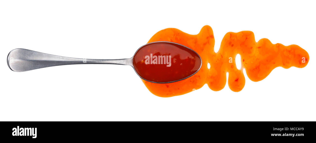 Sweet and sour sauce. Splashes and spilled orange sauce with spoon isolated on white background
