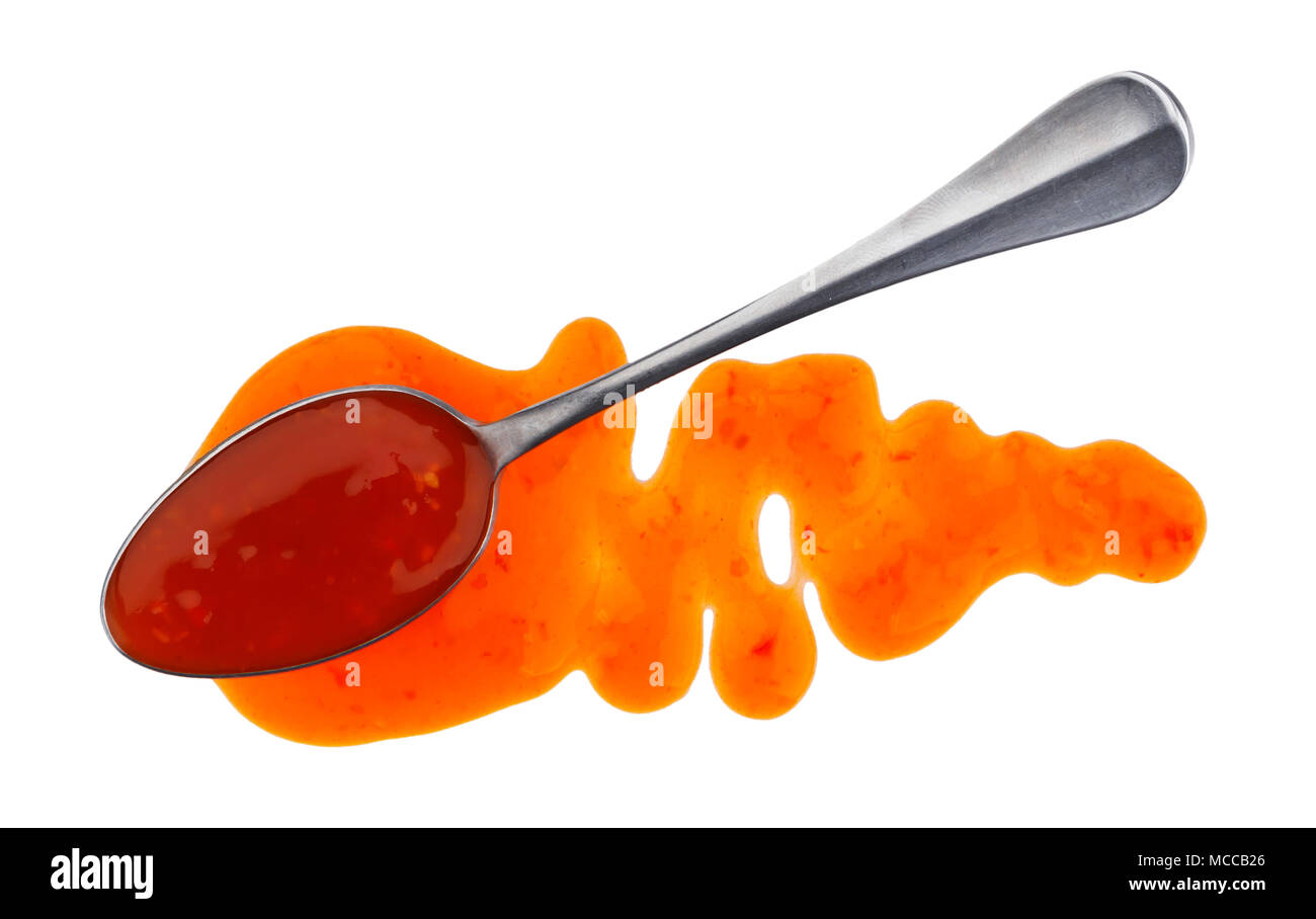 Sweet and sour sauce. Splashes and spilled orange sauce with spoon isolated on white background