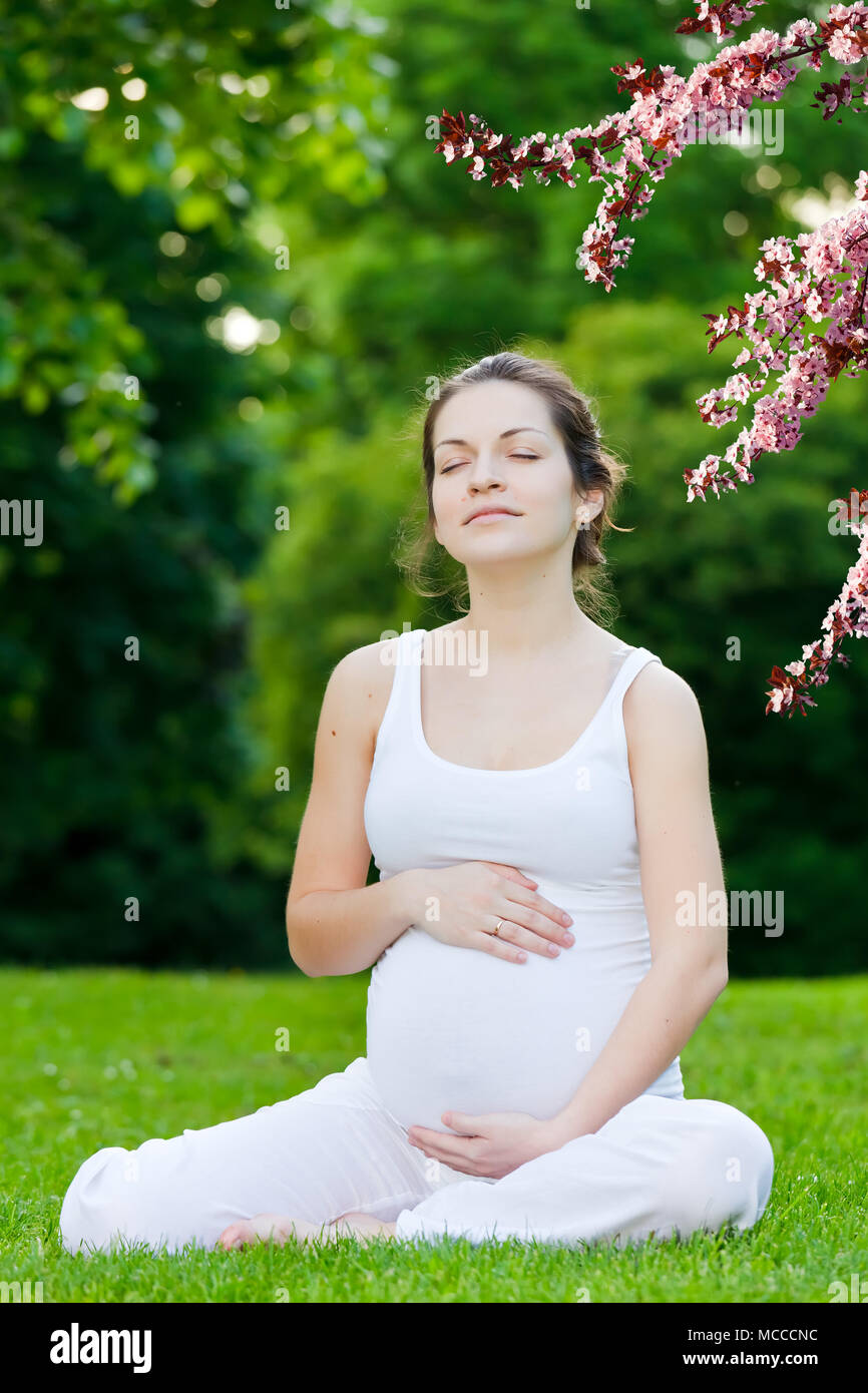 Beautiful pregnant woman in the spring park Stock Photo - Alamy