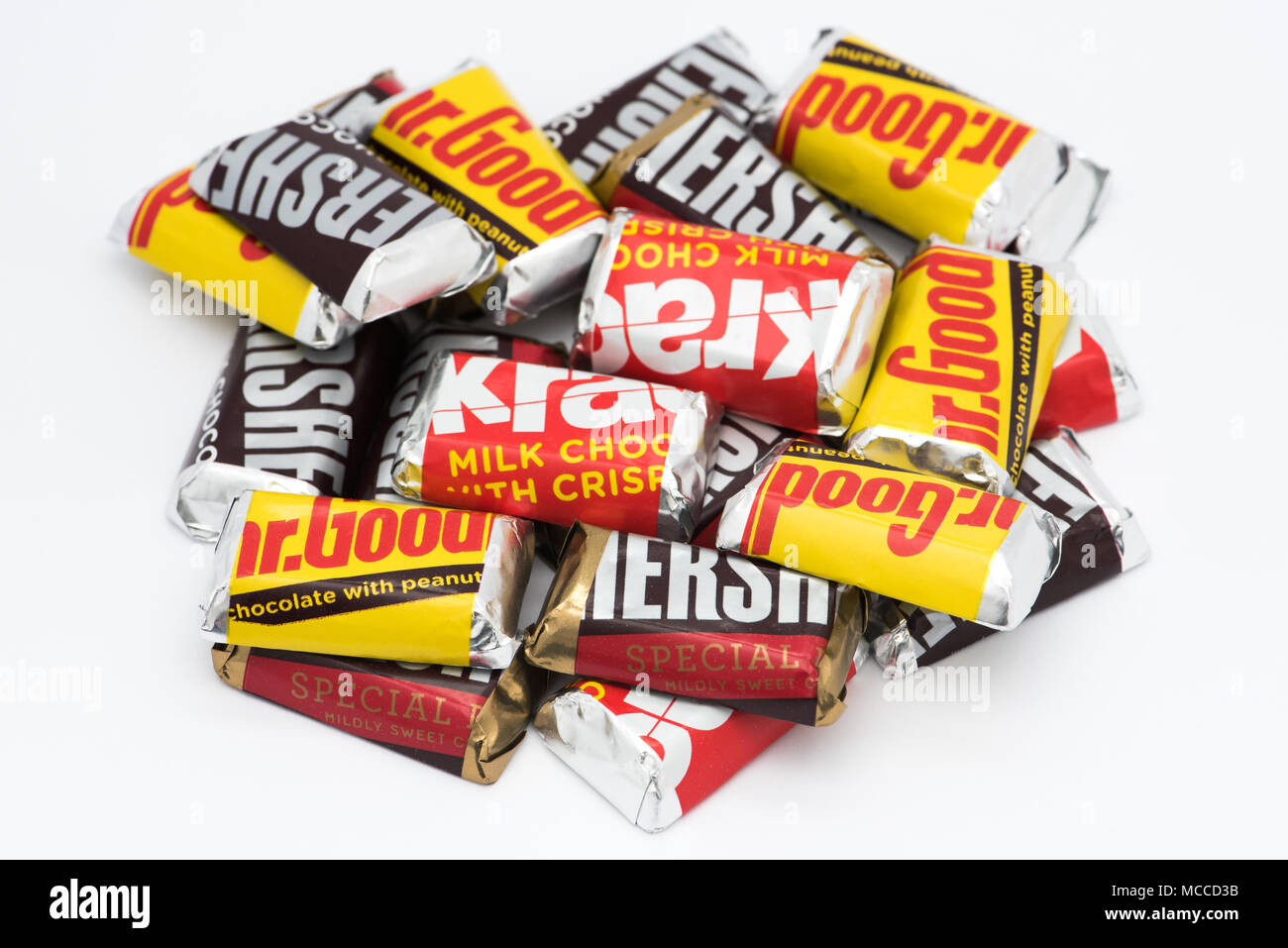 A pile of Hershey's miniature candy bars, in Milk Chocolate, Mr. Good bars, Krackel bars and Special Dark Chocolate flavors isolated. Stock Photo