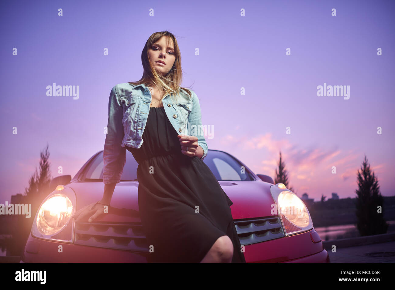 Beautiful girl fashionably stand near car Stock Photo