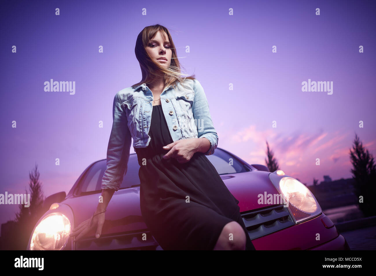 Beautiful girl fashionably stand near car Stock Photo