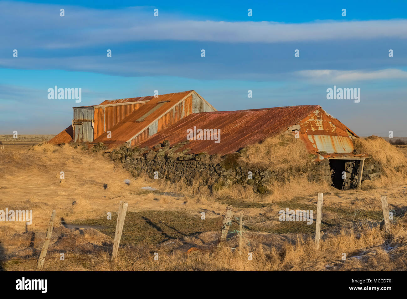 Old corrugated sheet metal barn bolstered on the sides with lava rocks ...