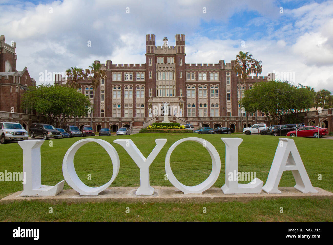 Loyola University, New Orleans, Louisiana, USA. White university sign with the name LOYOLA in front with university buildings behind sign. Horizontal. Stock Photo