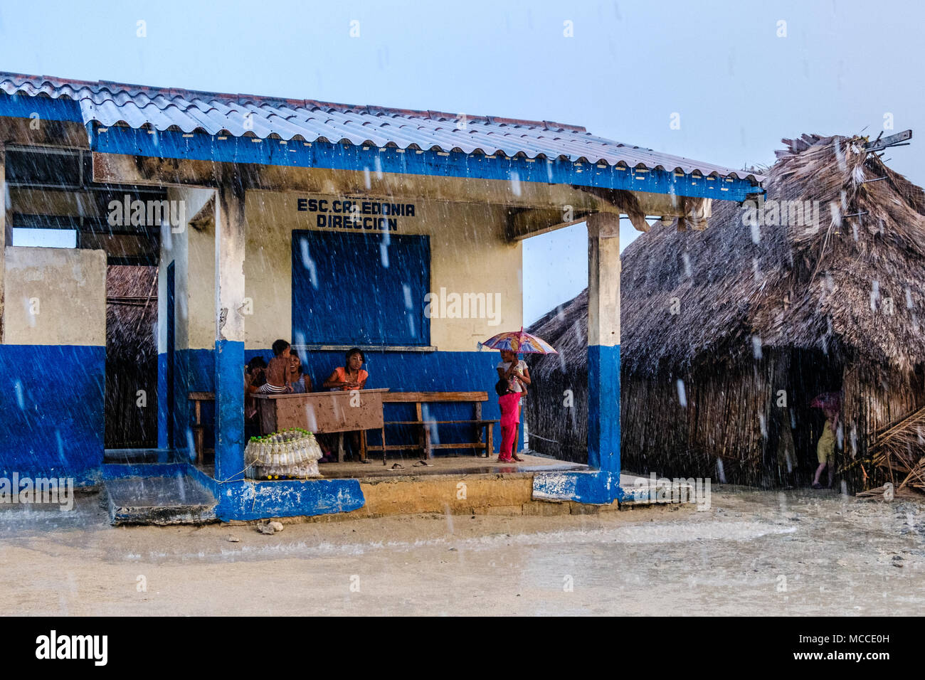 Guna Yala, Panama - march 2018: Group of young children with umbrella in rain on street in a Kuna Village Stock Photo