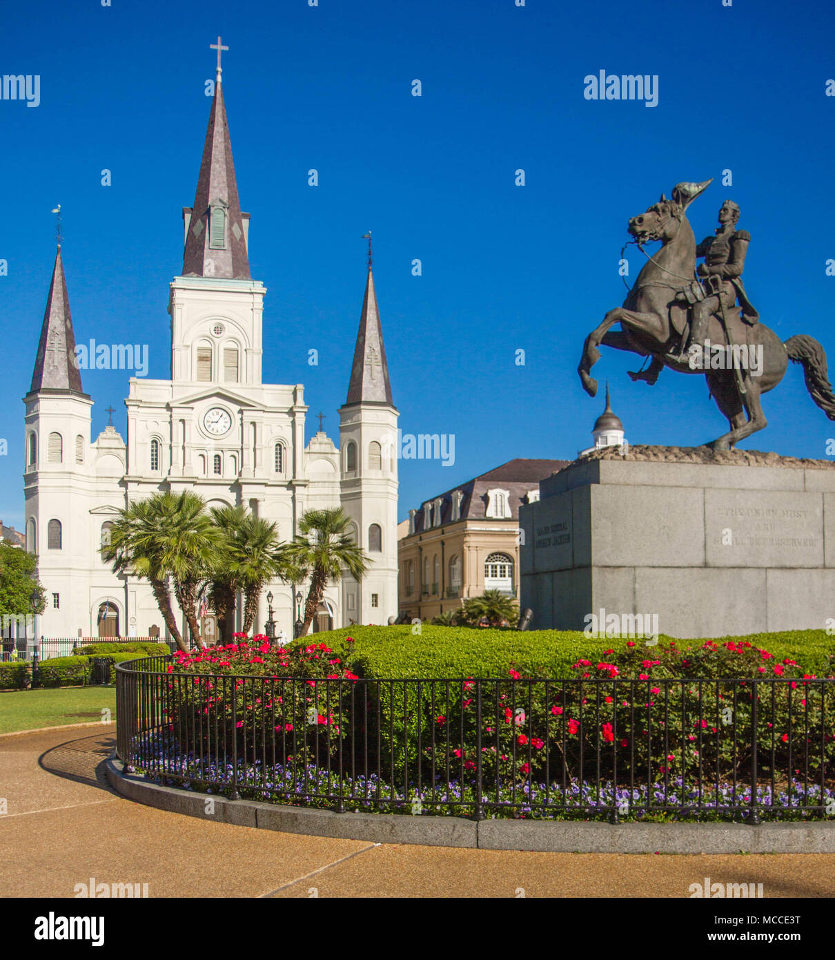 St. Louis Cathedral, Jackson Square, Louisiana, United States. Color vertical image with Andrew Jackson statue in foreground with red flowers. Stock Photo