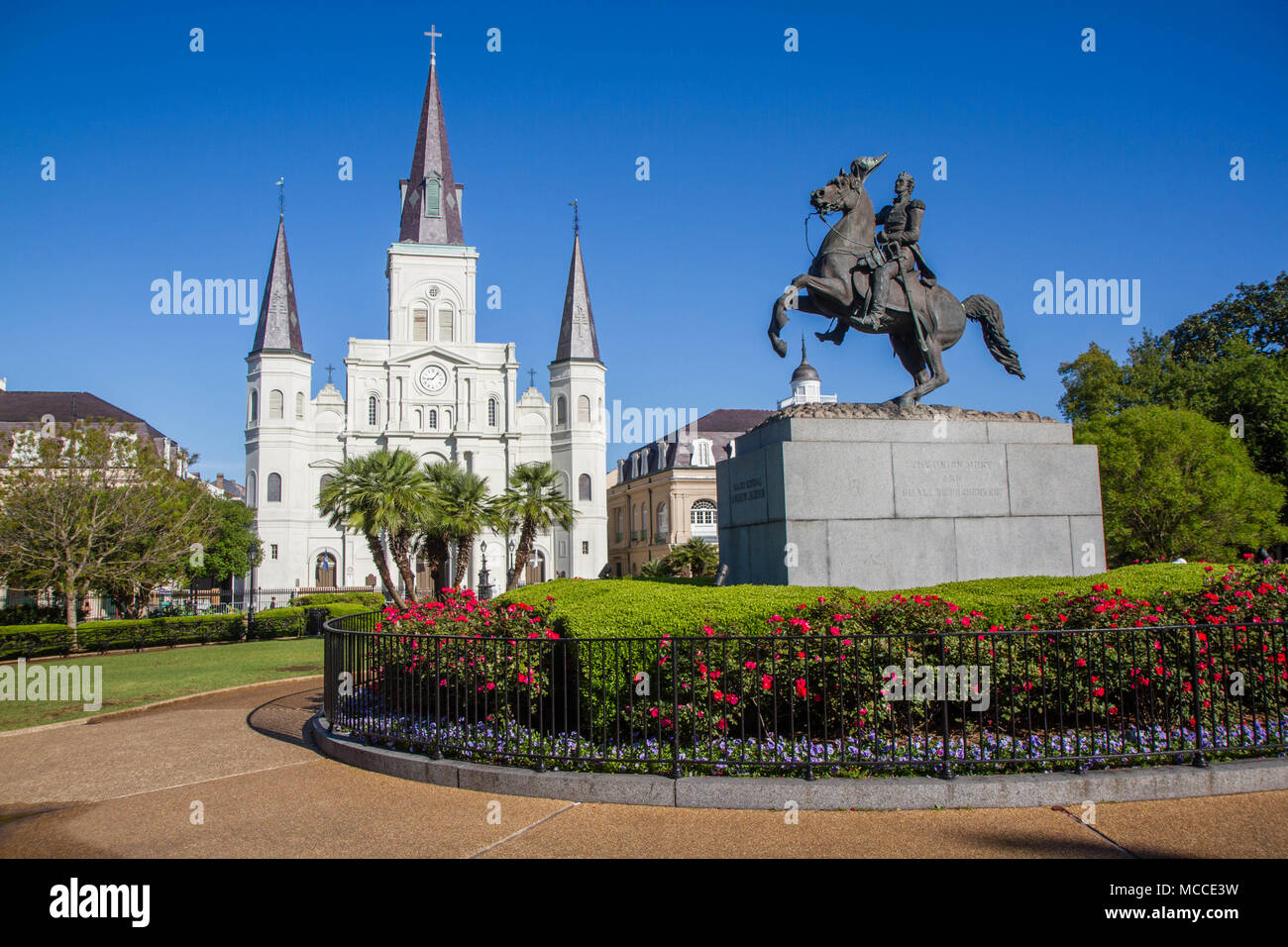 St. Louis Cathedral, Jackson Square, Louisiana, United States. Color horizontal image with Andrew Jackson statue in foreground with red flowers. Stock Photo