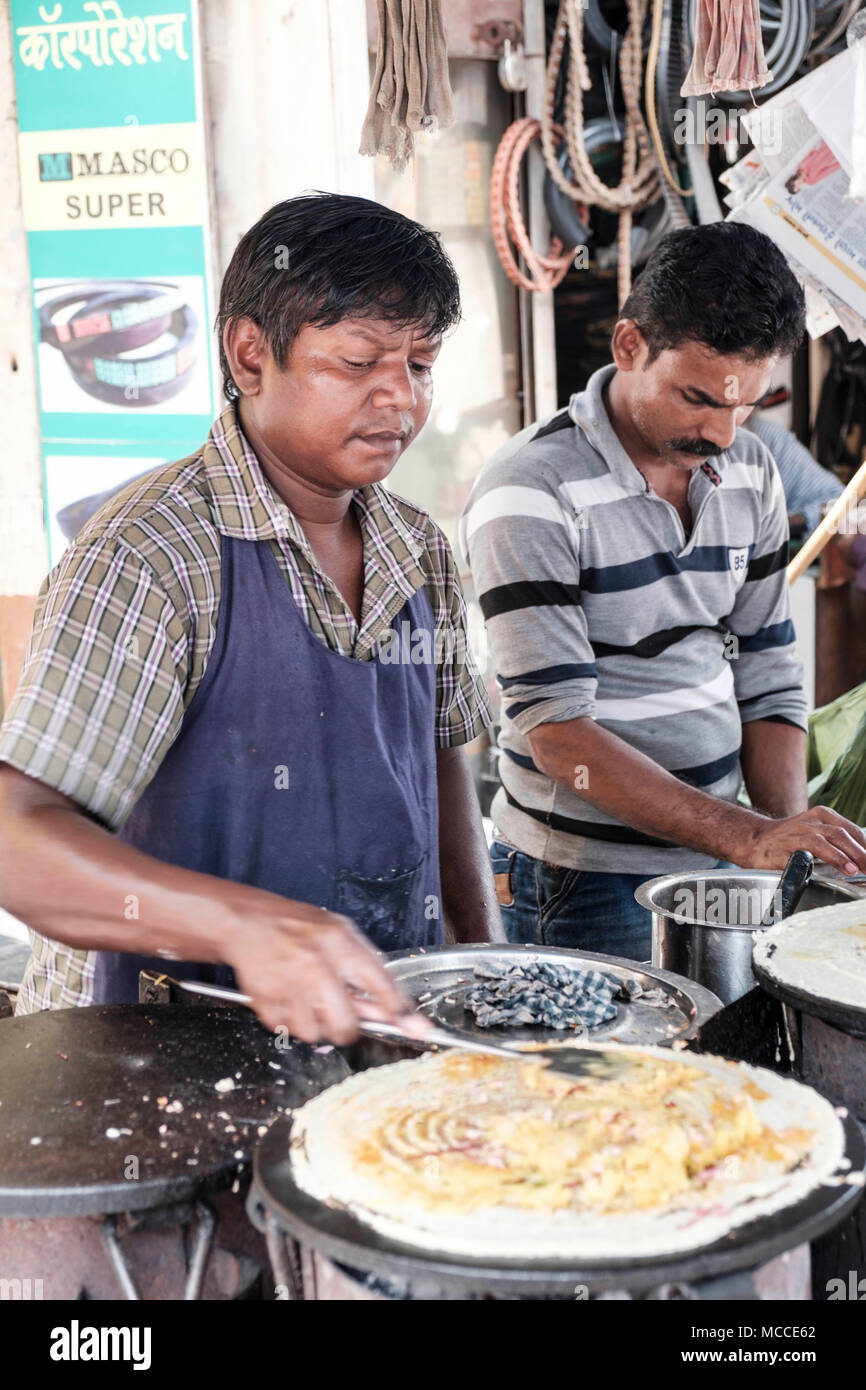 Cook making Masala Dosa on an outdoor hot plate in a Mumbai market Stock Photo