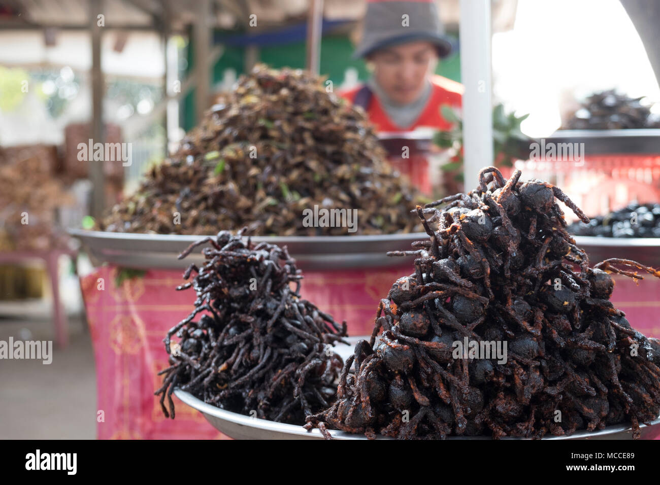 Woman frying tarantula spiders at a roadside stall in Cambodia Stock Photo
