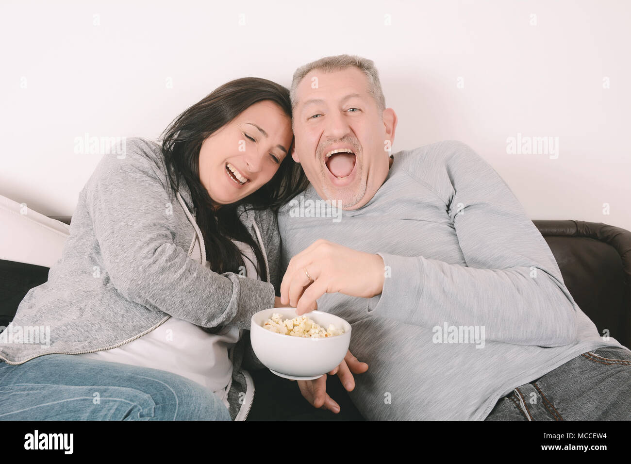 Mature couple eating popcorn watching hires stock photography and