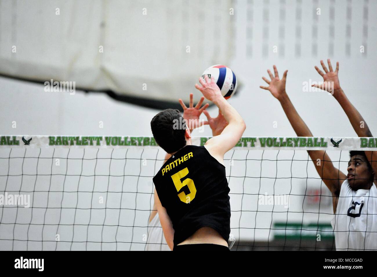 Player delivering a kill shot past a pair of opponents at the net. USA. Stock Photo