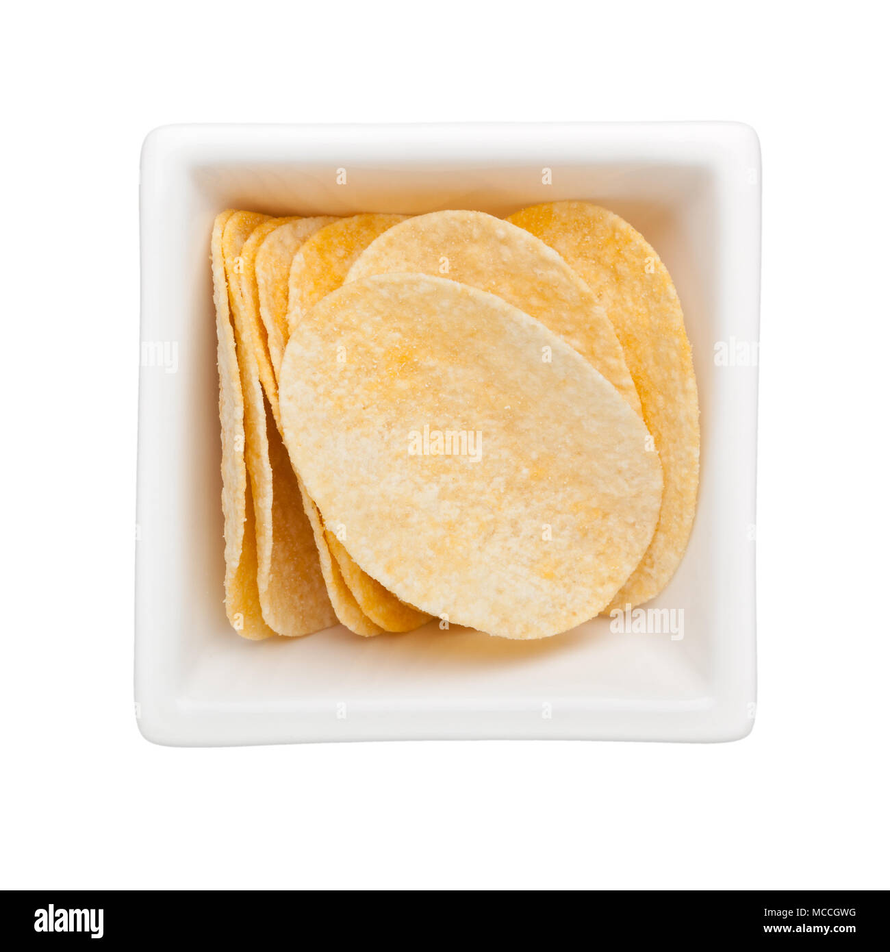 Pieces of potato crisps in a square bowl isolated on white background Stock Photo