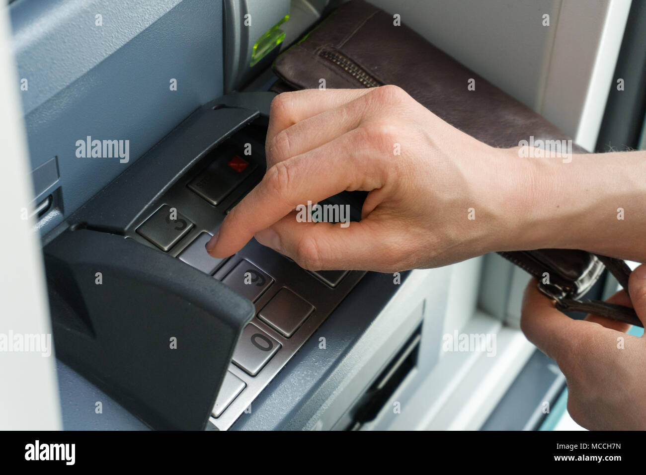 female hand entering a secure PIN code at a cash point or ATM up close ...