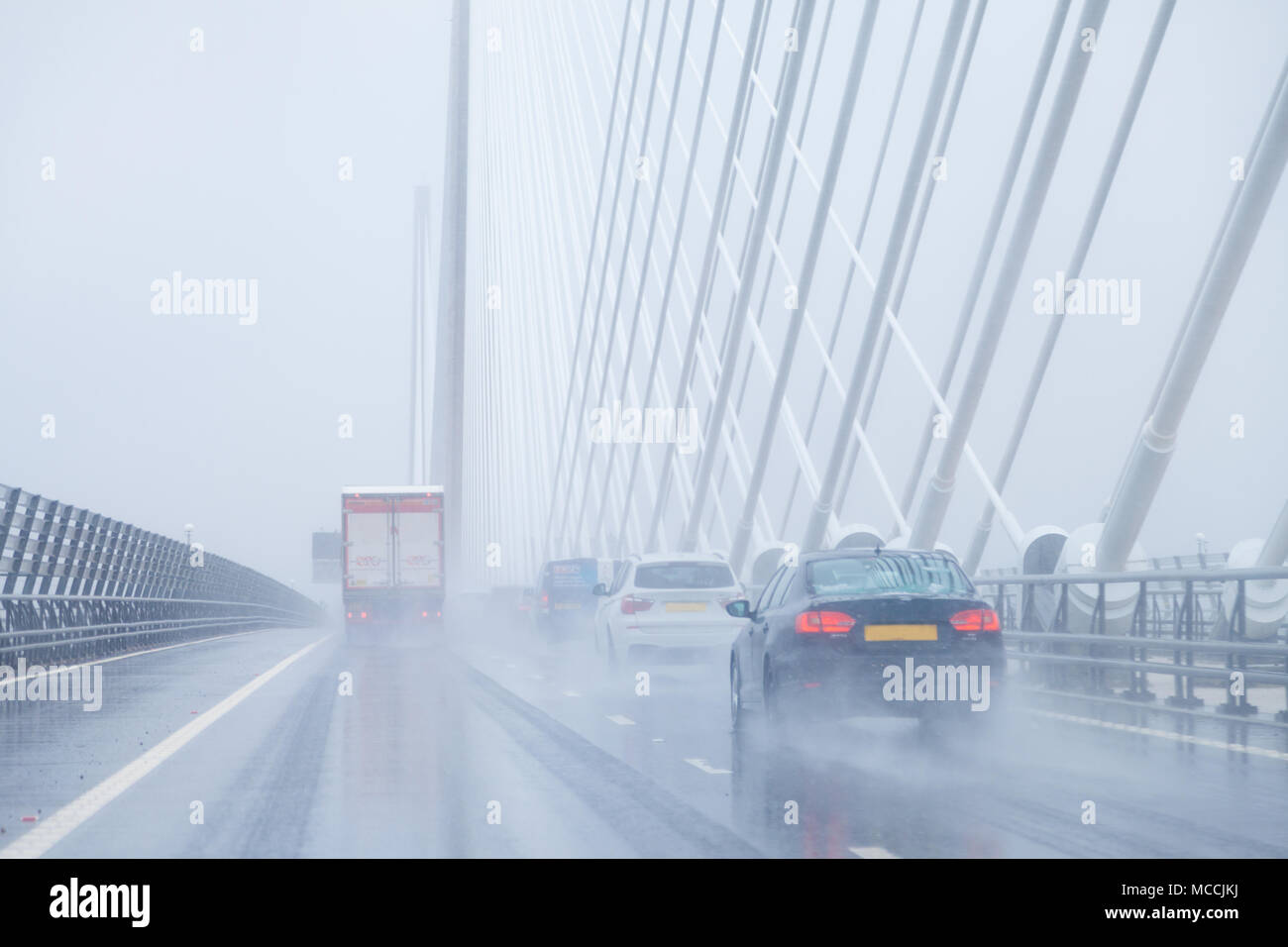 Cars crossing the Queensferry Crossing in very wet driving conditions, Fife, Scotland. Stock Photo