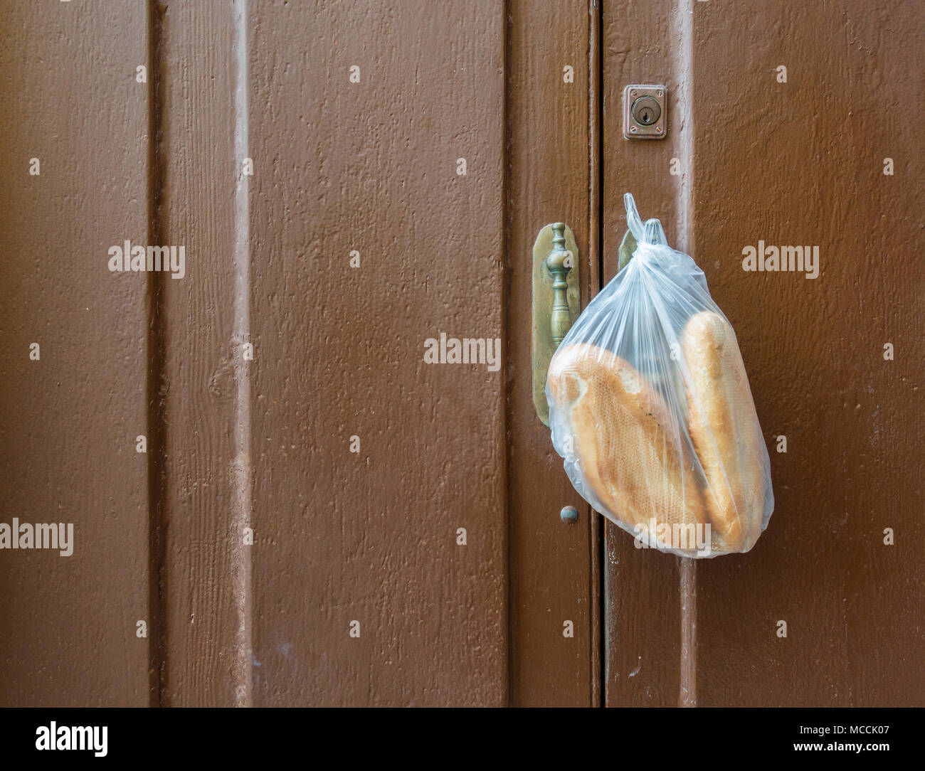 Bread hanging on door of house in village in Spain. A bread delivery van makes home deliveries in most Spanish villages. Stock Photo