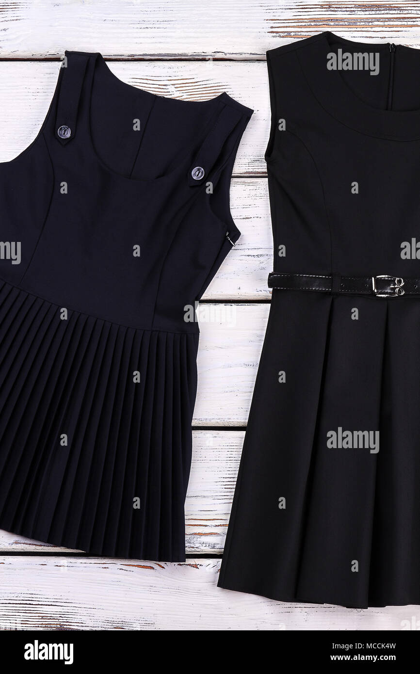 School girls classic black dresses. New cotton black shool dresses for girls  on sale. Belted and pleated girls dresses for school wear Stock Photo -  Alamy