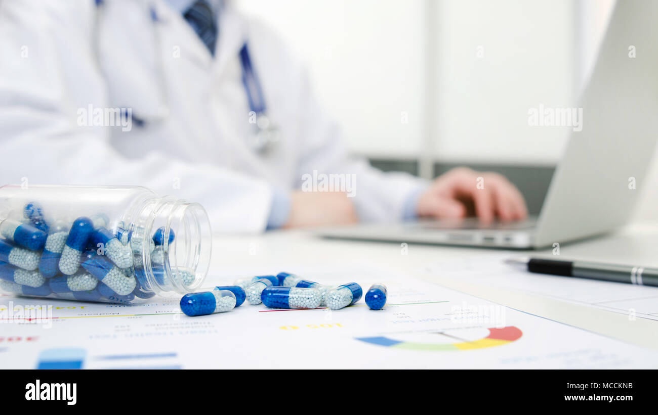 Doctor working in hospital. Pills spilled on the doctor's desk. Medical doctor healthcare consultation in polyclinic or hospital concept Stock Photo