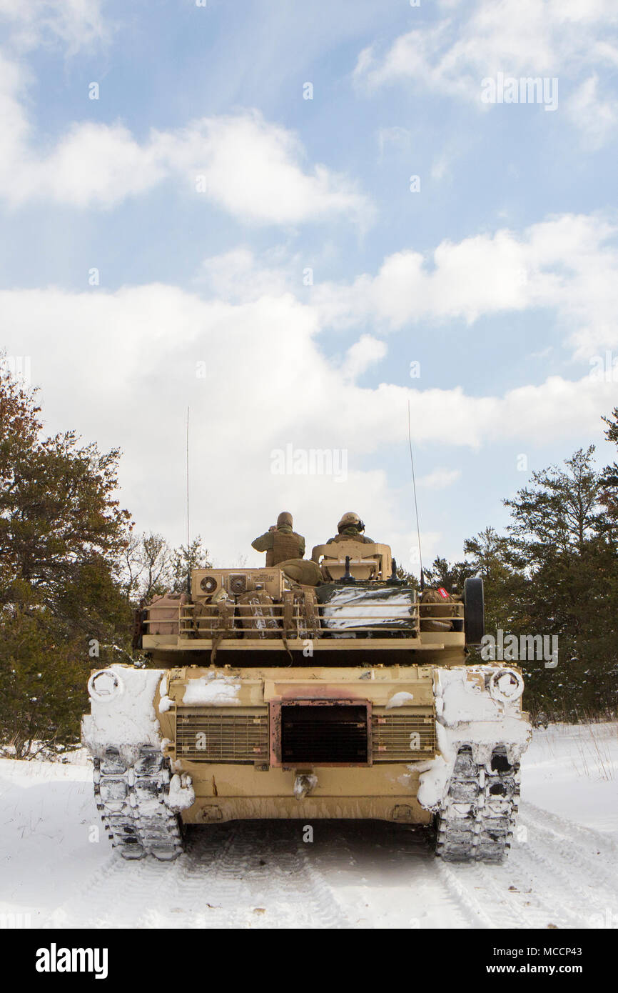 Marines with Company F, 4th Tank Battalion, 4th Marine Division, pause to check the scheme of maneuver before a platoon formation rehearsal during exercise Winter Break 2018 near Camp Grayling, Michigan, Feb. 8, 2018. Winter Break 18 challenges Marines of Fox Co., 4th Tank Bn. to contend with employment problems caused by extreme cold weather and snow and adapt to the operational challenges of a severe climate. Stock Photo