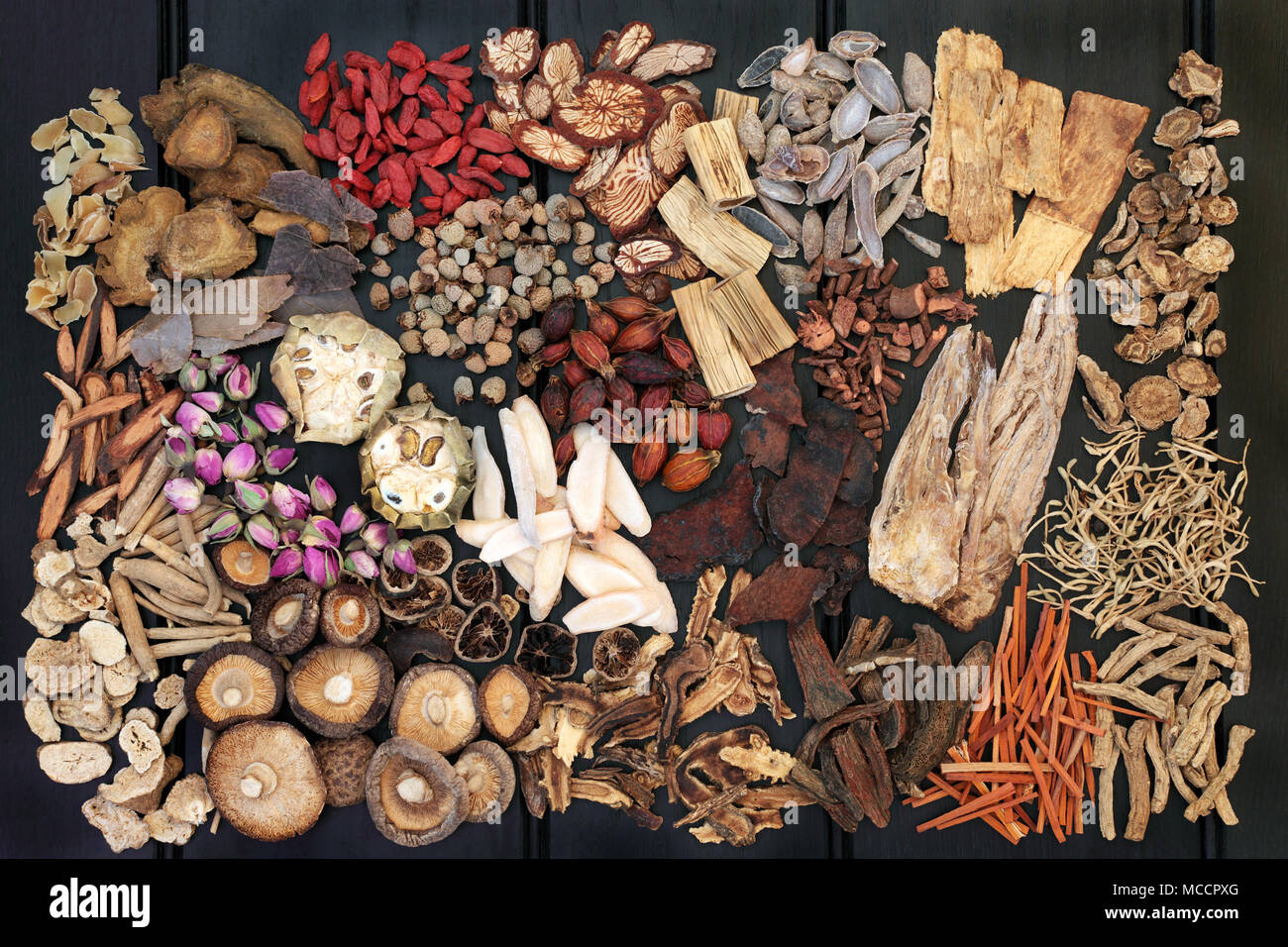 Traditional chinese herbs used in alternative herbal medicine on dark wood background. Top view. Stock Photo
