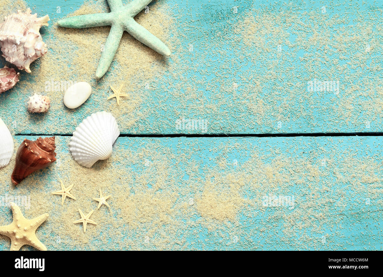 Summer sea background. Starfish, seashells and sand on a wooden blue background. Stock Photo
