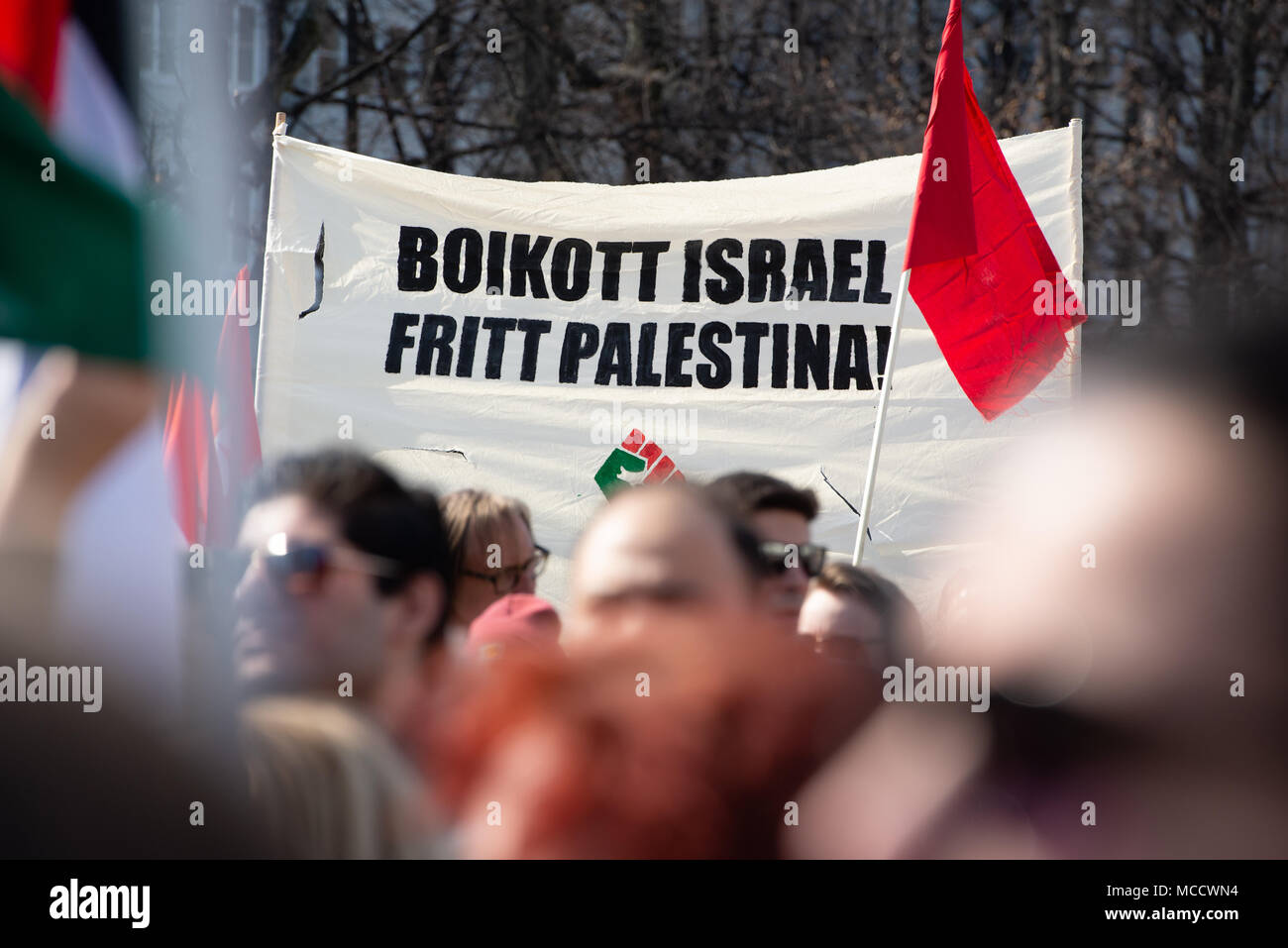 Protesters carry a sign reading 'Boycott Israel, Free Palestine!' as they march to Norway’s parliament building to protest Israel's shooting of Palestinians in Gaza. Oslo, April 14, 2018. Stock Photo