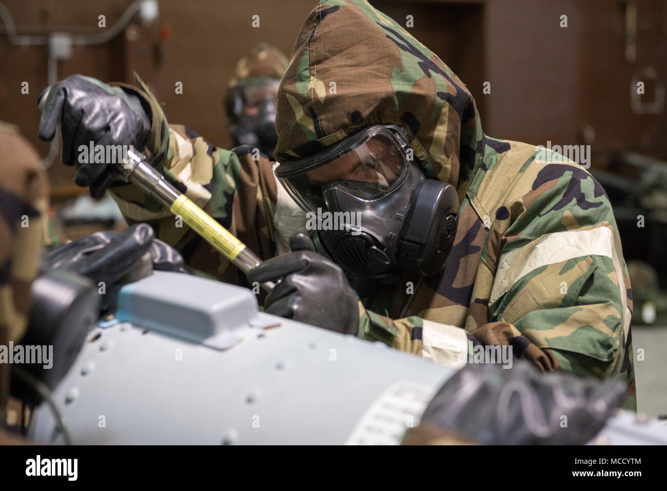 An Air Force munitions crew chief with the 477th Maintenance Squadron  practices building an inert Joint Direct Attack Munition Guided Bomb Unit  32 while wearing level-4 mission oriented protective posture (MOPP) gear