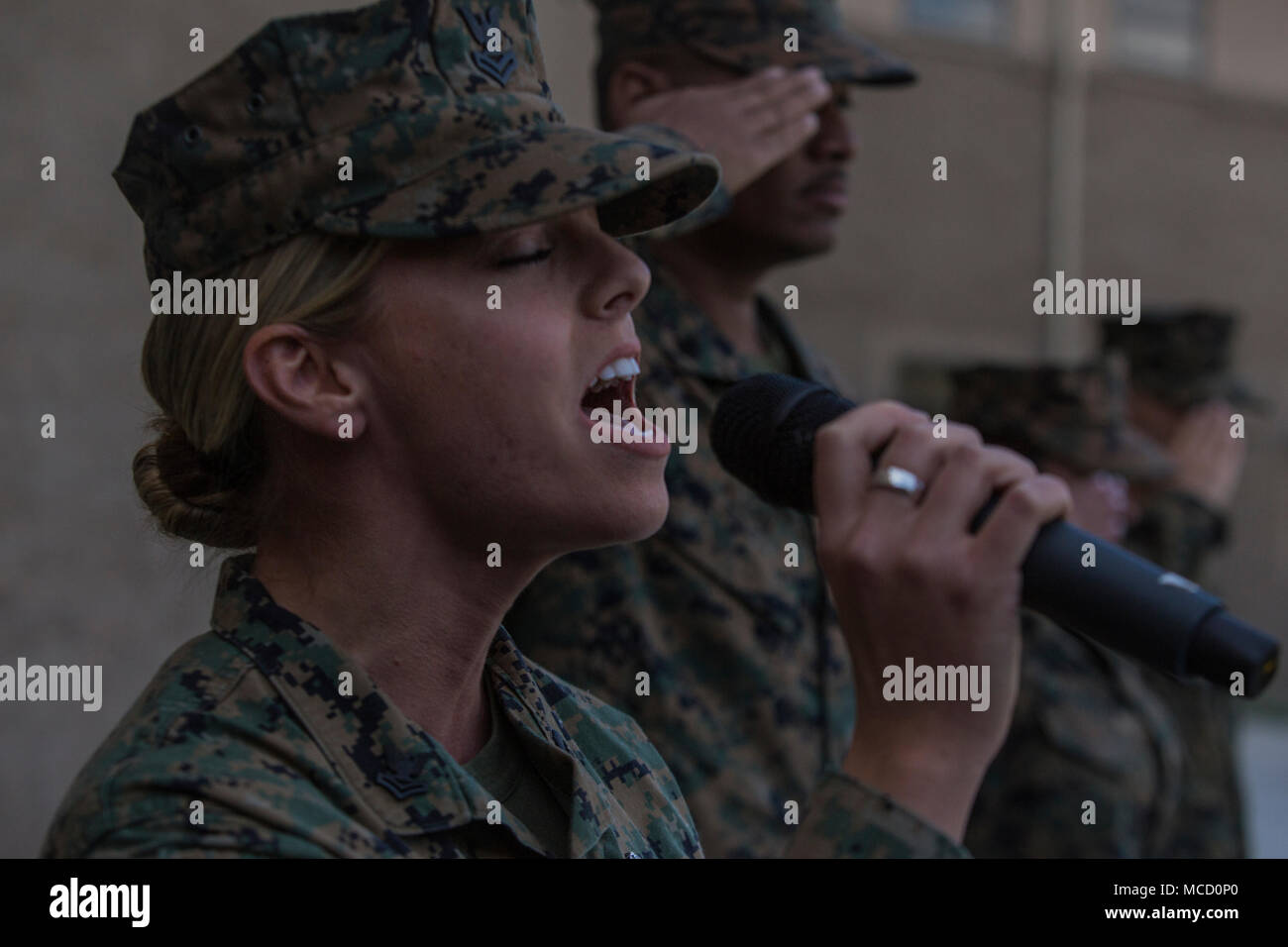 U.S. Navy Petty Officer 2nd Class Ashley Raynor, a hospital corpsman with 1st Marine Logistics Group, sings the National Anthem during the appointment ceremony for Master Chief Petty Officer Zachary Pryor, who will become the command master chief for the 1st MLG, at Camp Pendleton, Calif., Feb. 13, 2018. Pryor was appointed as the command master chief for all medical and dental personnel within the 1st MLG. (U.S. Marine Corps photo by Cpl. Adam Dublinske) Stock Photo