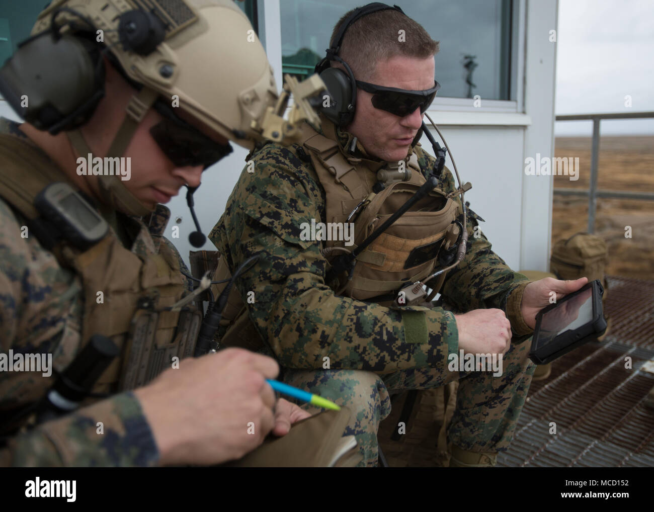 Major Michael Sedrick and Captain Michael Valdez, Marines with 2nd Air Naval Gunfire Liaison Company, discuss possible plans for a simulated scenario during close air-support drills at an aircraft attack range on Piney Island, North Carolina, Feb. 7, 2018. The Marines practiced making flight and attack plans for the pilots depending on specific situations. (U.S. Marine Corps photo by Lance Cpl. Ashley McLaughlin) Stock Photo