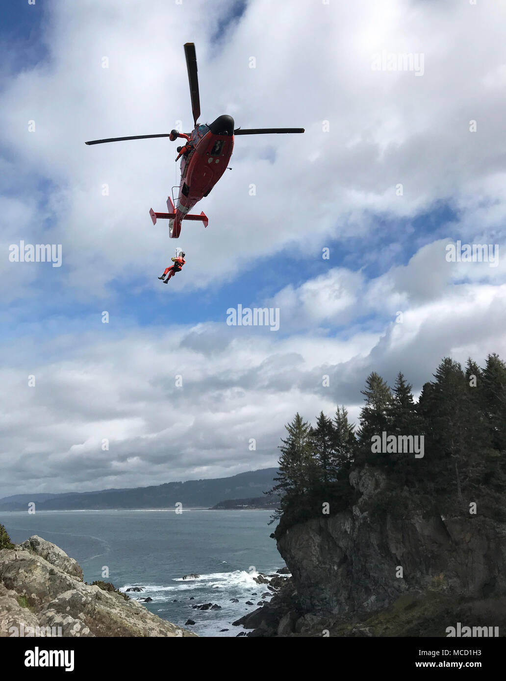 A Coast Guard Sector Humboldt Bay MH-65 Dolphin helicopter crew conducts cliff-rescue training at Patrick's Point State Park, California, Feb. 14, 2018. The helicopter crews assigned to Sector Humboldt Bay cover Humboldt, Mendocino and Del Norte counties. (U.S. Coast Guard photo by Lt. j.g. Audra Forteza/Released) Stock Photo