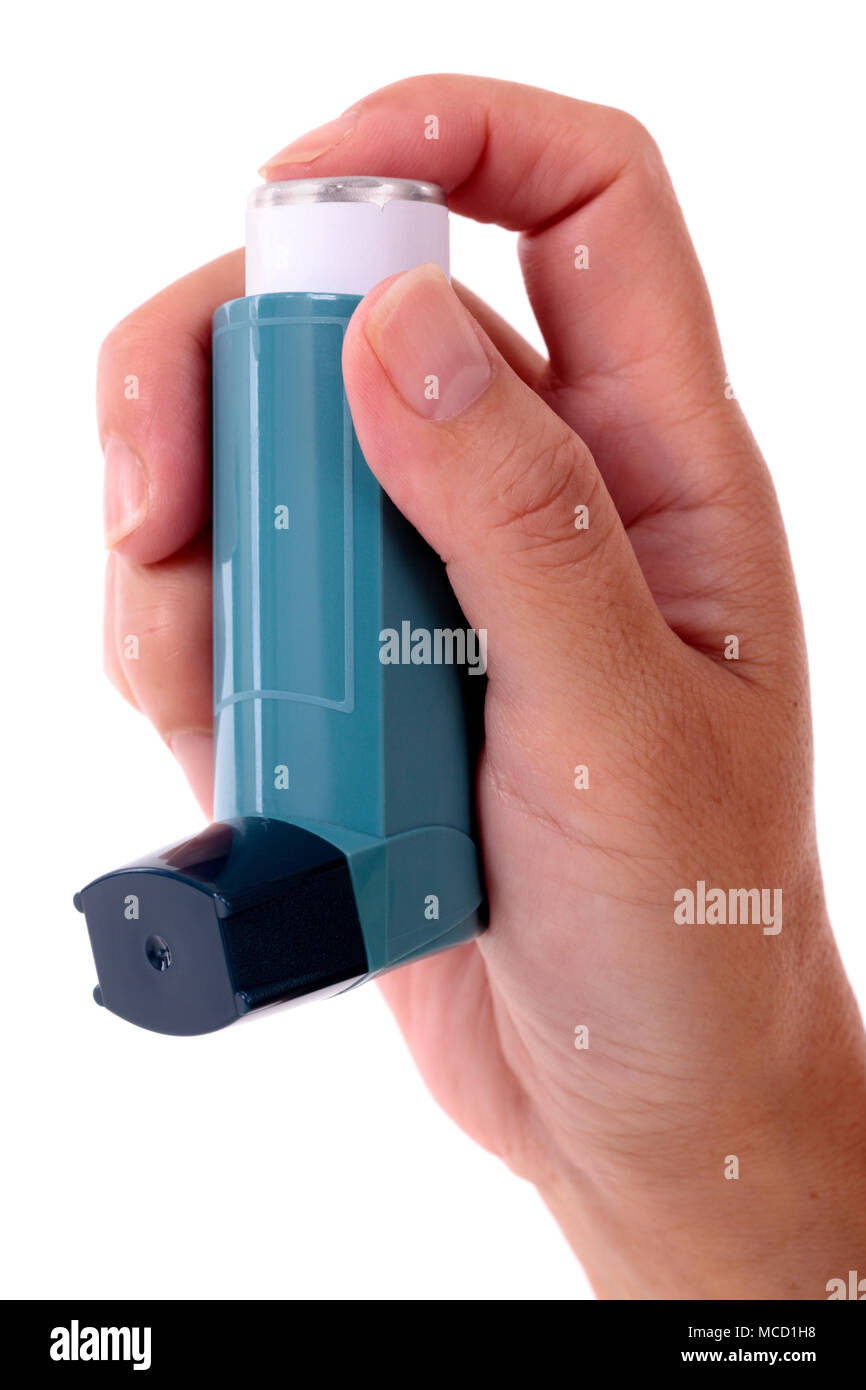Asthma inhaler held in hand isolated on white background, vertical Stock Photo