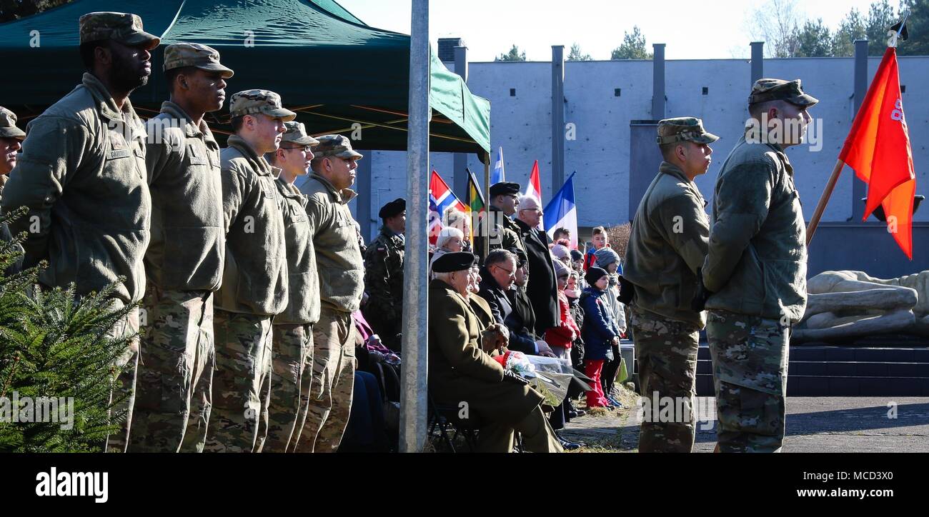 The Soldiers of Company C, 82nd Brigade Engineer Battalion, 2nd Armored Brigade Combat Team, 1st Infantry Division, and a collective of Polish families and veterans listen to a speech during a ceremony in honor of the 73rd anniversary of the Battle of Zagan outside of the Stalag Luft III Prisoner Camp Museum in Zagan, Poland on Feb. 16, 2018. The U.S. Soldiers attended the event to strengthen Polish-American relationships during their deployment in support of Atlantic Resolve and to learn about the history of the community in which they serve. (U.S. Army photo by Spc. Hubert D. Delany III / 22 Stock Photo
