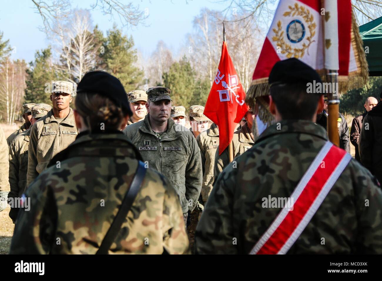 Capt. Jason Morehouse (center), a Moody, Texas native and the commander of Company C, 82nd Brigade Engineer Battalion, 2nd Armored Brigade Combat Team, 1st Infantry Division, stands at attention in front of his Soldiers during a ceremony in honor of the 73rd anniversary of the Battle of Zagan outside of the Stalag Luft III Prisoner Camp Museum in Zagan, Poland on Feb. 16, 2018. The U.S. Soldiers attended the event to strengthen Polish-American relationships during their deployment in support of Atlantic Resolve and to learn about the history of the community in which they serve. (U.S. Army pho Stock Photo