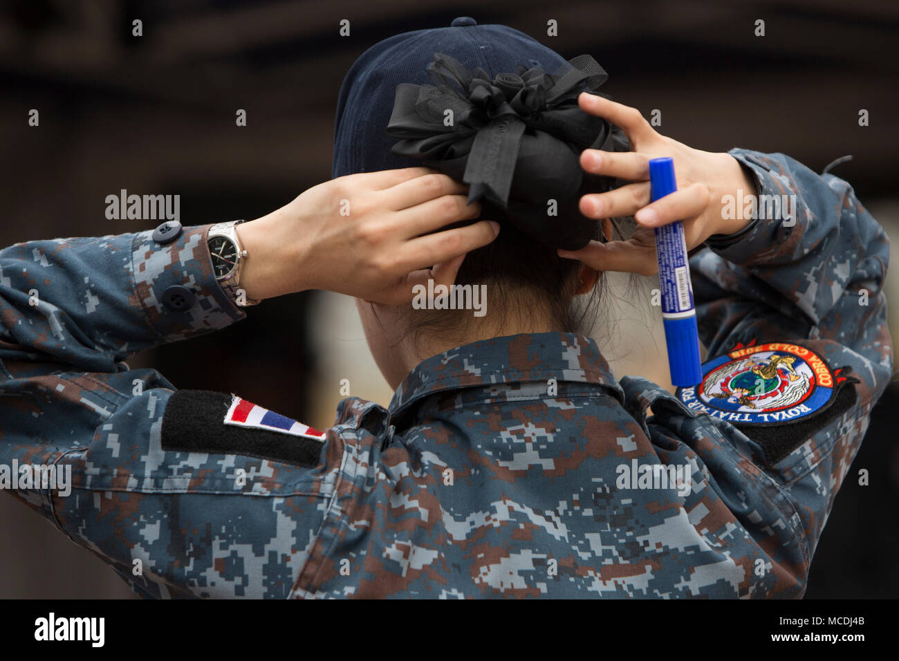 A member of the Royal Thai Air Force fixes her hair during the construction  of a Field Hospital during Exercise Cobra Gold 2018 in Chachoengsao,  Kingdom of Thailand, Feb. 19, 2018. Cobra
