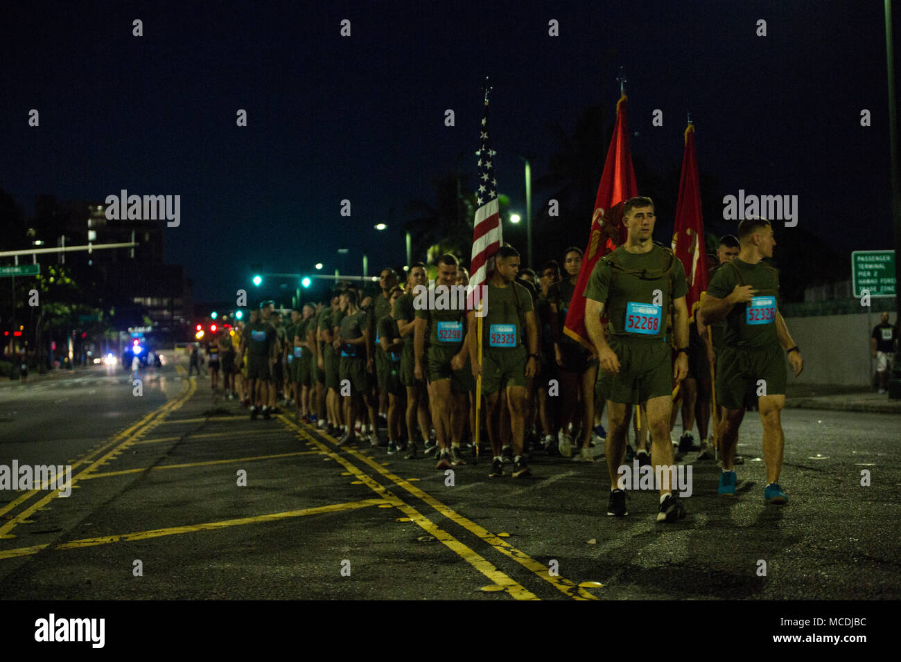 U.S. Marine Corps Forces, Pacific, Marines march to the ready line at the start of the 34th annual Great Aloha Run in Hawaii, Feb. 19, 2018. Marines and Sailors participated in the “Sounds of Freedom” portion of the 8.15-mile Great Aloha Run, which consisted of military units running in formation and calling cadence to build camaraderie, and esprit de corps and strengthen ties with the local community.  (U.S. Marine Corps photo Pvt. Sandra A. Garduno) Stock Photo