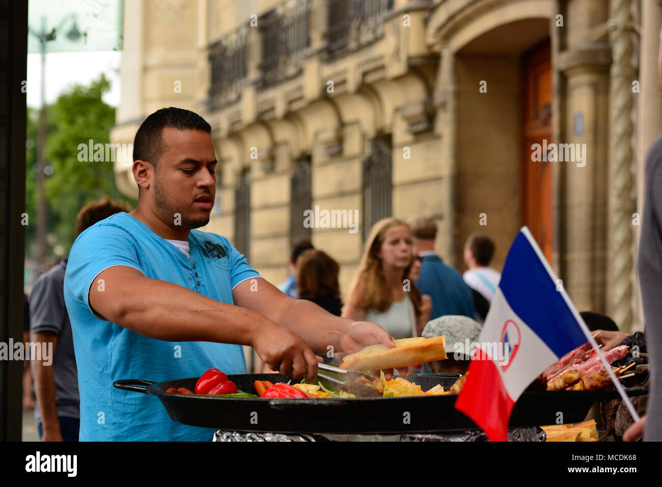 Street vendor grilling sausages and spiced chicken on the streets of Paris Stock Photo