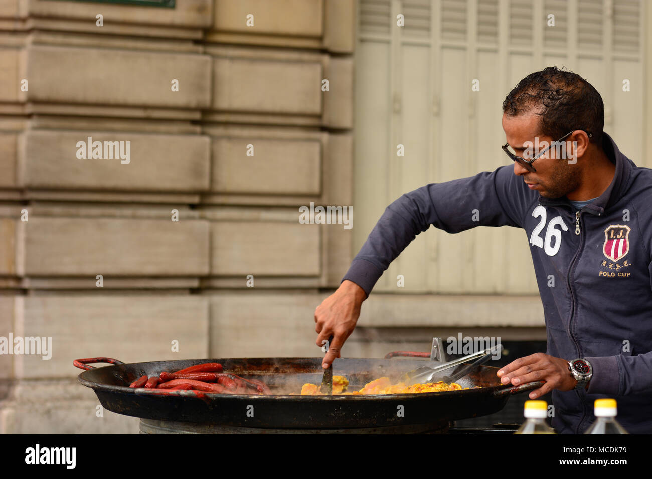 Street vendor grilling sausages and spiced chicken on the streets of Paris Stock Photo