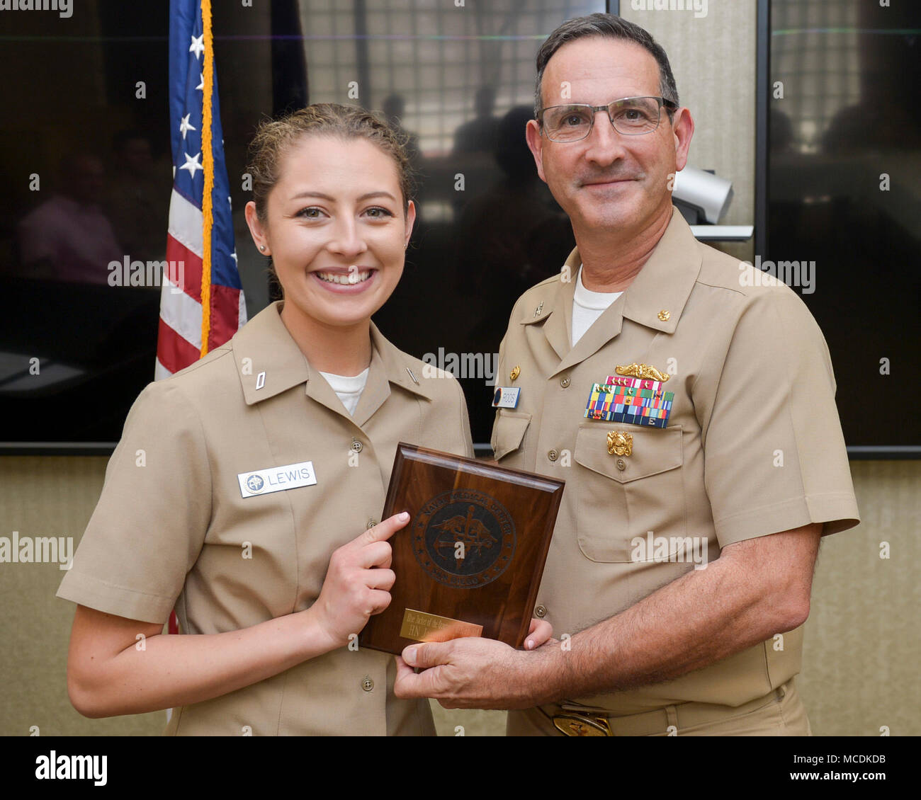 180216-N-PN275-1006 SAN DIEGO (Feb. 16, 2018) CAPT. Joel Roos, Naval Medical Center San Diego Commanding Officer,  presents Hospital Corpsman Jasmine Lewis with the Bluejacket of the Quarter award. Hospital Corpsman Lewis received the award for her exceptional work and devotion to duty. (U.S. Navy Photo by Mass Communication Specialist 2nd Class Zachary Kreitzer) Stock Photo