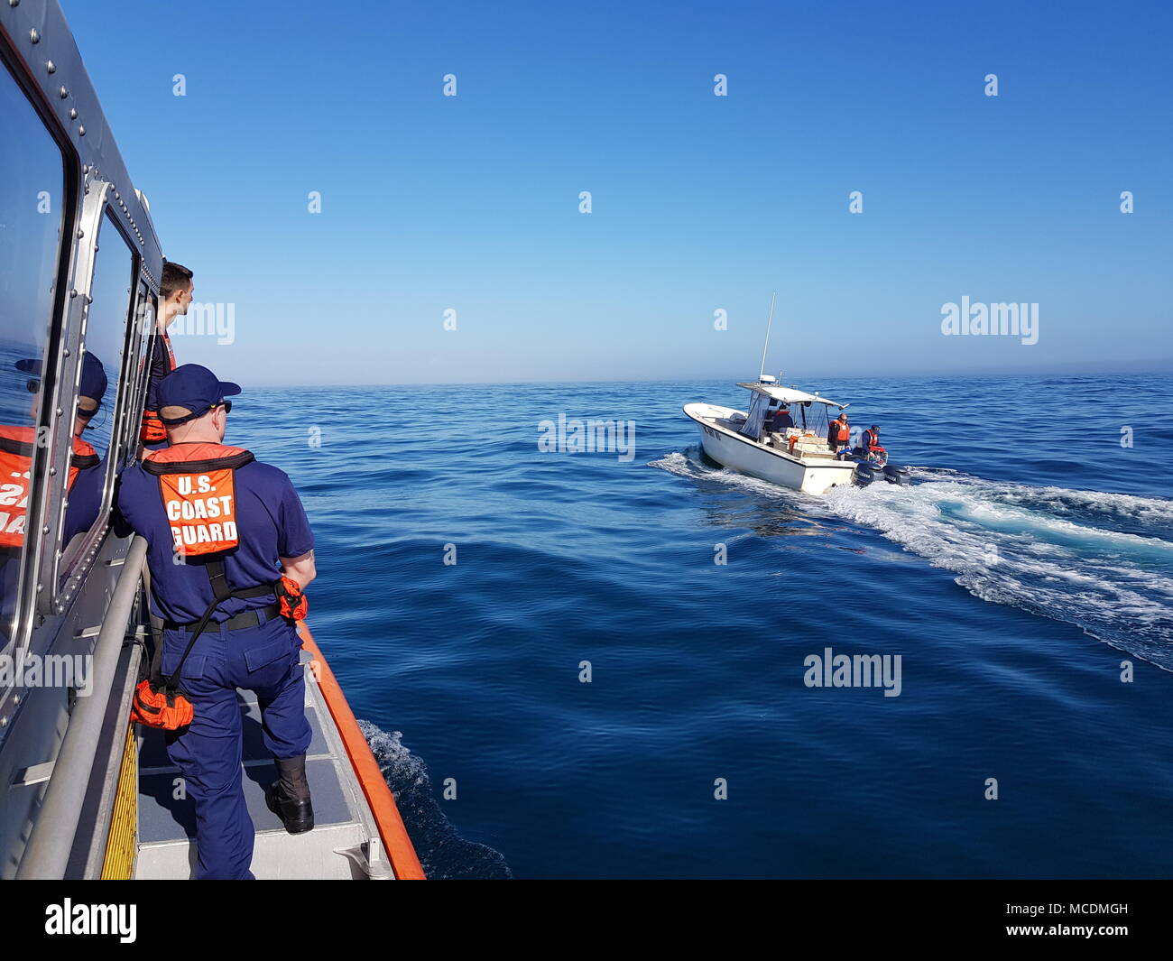 Coast Guard Station Wrightsville Beach 45-Foot Response Boat—Medium boat crew members, Fireman Thomas Kenny, Petty Officer 3rd Class Brett Weaver and Petty Officer 2nd Class Zachary Timm, dewater and escort a boat that was sinking approximately 13 miles off the coast of Carolina Beach, North Carolina, on Feb. 21, 2018. The boaters reportedly hit a floating piece of debris, which created a gash in the hull.  (U.S. Coast Guard photo by Fireman Nolan Jackson/Released) Stock Photo