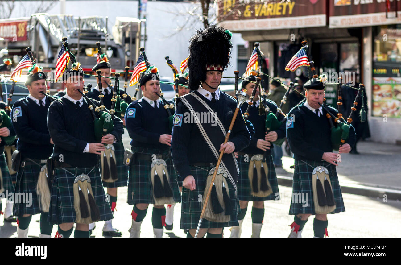 Police officers with the Pipes & Drums of the Emerald Society lead the