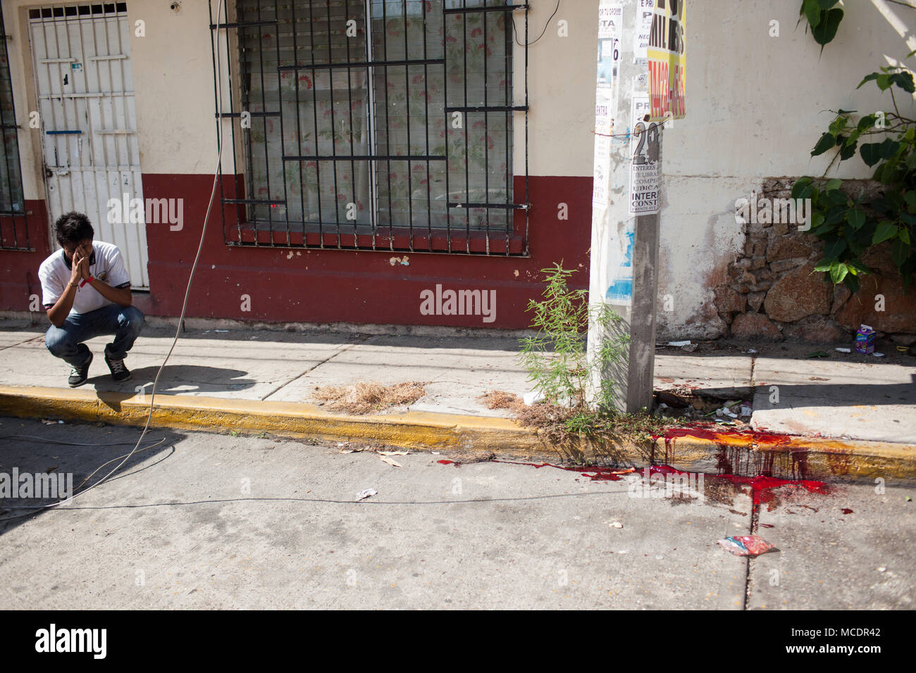 A family member of Acapulco Police Force lawyer Jesœs Antonio Lemus Beltr‡n near the scene of his murder in the Colonia Progreso of Acapulco, Guerrero, Mexico on Wednesday, November 18, 2015. Beltr‡n was murdered leaving his house.   Acapulco is one of Mexico's best known beach resorts, hosting many famous celebrities during the 1950s. However, constant violence has largely affected the city's international image and foreign tourism numbers. Stock Photo