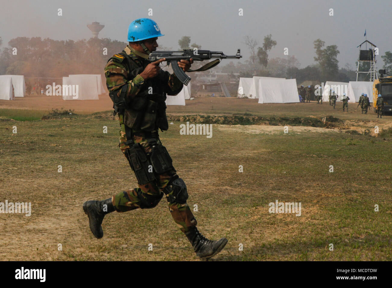 A Bangladesh Army soldier of the Para-Commando Brigade runs to secure a drop zone during a rehearsal for a demonstration as part of Exercise Shanti Doot 4 in Bangladesh. Shanti Doot 4 is a multinational United Nations peacekeeping exercise with more than 1,000 participants from more than 30 countries designed to provide pre-deployment training to U.N. partner countries in preparation for real-world peacekeeping operations. (U.S. Marine Corps photo by Lance Cpl. Adam Montera) Stock Photo