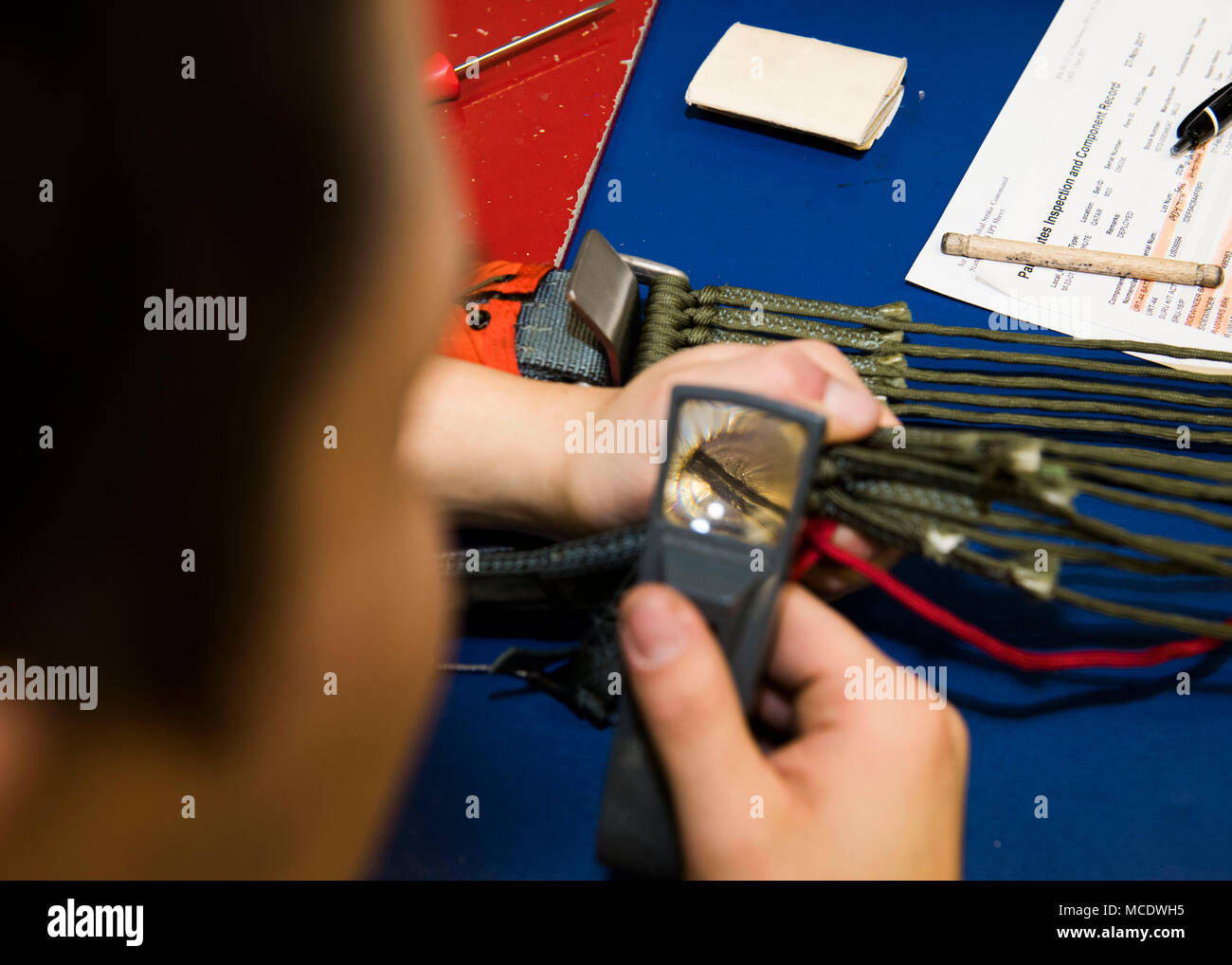 Senior Airman Austin Galvan, 5th Operations Support Squadron aircrew flight equipment journeyman, inspects the yoke and plate assembly of a back-automatic parachute at Minot Air Force Base, N.D., Feb. 21, 2018. The AFE flight is responsible for maintaining and inspecting all life-saving equipment on the B-52H Stratofortress prior to each mission, and are on-duty for each take-off and landing to correct any potential aircrew-related equipment issues. (U.S. Air Force photo by Airman 1st Class Alyssa M. Akers) Stock Photo