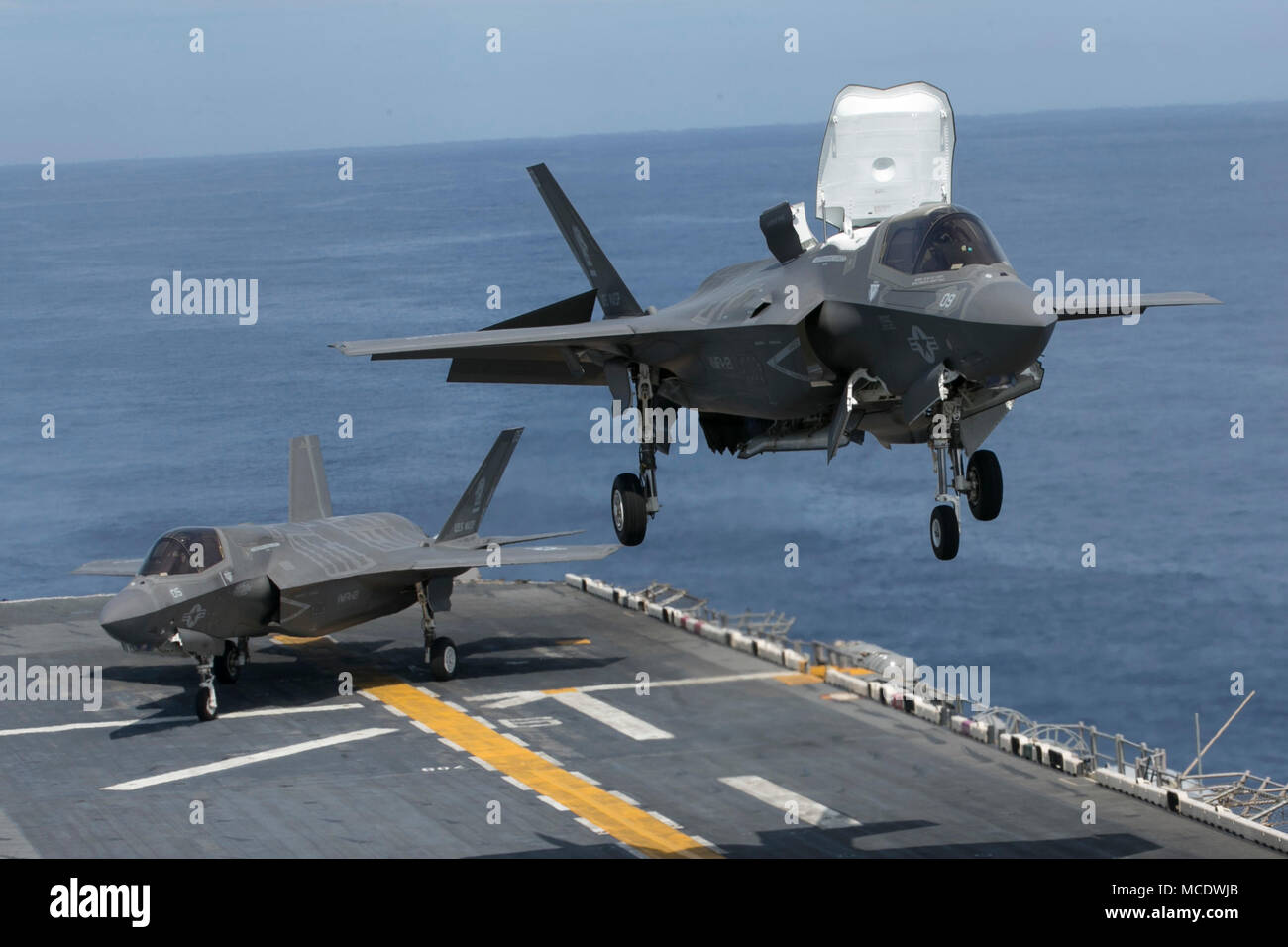 An F-35B Lightning II prepares to land on the flight deck of the USS Wasp (LHD-1) while off the coast of Okinawa, Japan, April 13, 2018. A detachment of F-35Bs with Marine Fighter Attack Squadron 121 joined the USS Wasp for Spring Patrol 2018, marking the F-35’s first operational deployment with a MEU. As the Marine Corps’ only continuously forward-deployed MEU, the 31st Marine Expeditionary Unit provides a flexible force ready to perform a wide range of military operations throughout the Indo-Pacific region. (U.S. Marine Corps photo by Lance Cpl. Amy Phan/Released) Stock Photo