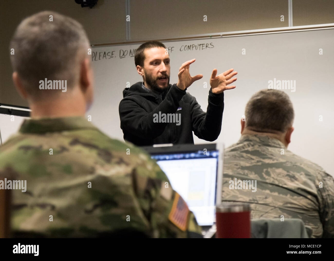 Richard Gloo, senior software engineer at Assured Information Security, Inc., gives a demonstration on cyber threats and how to recognize them to service members taking part in Exercise Arctic Eagle 2018, Joint Base Elmendorf-Richardson, Alaska, Feb. 27.  The purpose of this training is to ensure service members can proficiently identify cyber threats in real-life scenarios, and can operate in a joint, interagency, intergovernmental and multinational environment.  (Alaska Army National Guard photo by Pfc. Grace Nechanicky) Stock Photo
