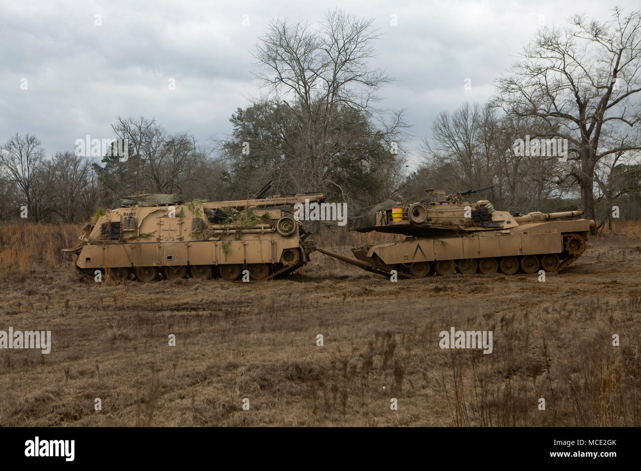 A M1A1 Abrams Main Battle Tank with 2nd Tank Battalion, 2nd Marine Division, is towed by a M88 Hercules Recovery Vehicle during fire and maneuver training operations aboard Fort Stewart, Ga., Feb. 10, 2018. This exercise ensures the unit can effectively employ their tanks in combat scenarios as well as provide support for adjacent units. (U.S. Marine Corps photo by Cpl. Alexander Sturdivant) Stock Photo