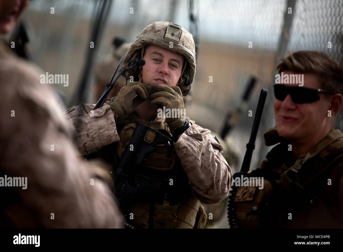 A U.S. Marine with Task Force Southwest straps up his helmet prior to a ...