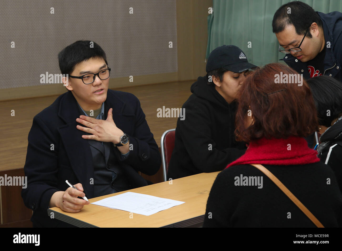 Sgt. Jungwoo Jang, a Korean Augmentation to the U.S. Army (KATUSA) assigned to Headquarters and Headquarters Battery, 210th Field Artillery Brigade, 2nd Infantry Division/ROK-US Combined Division tests participants of the Dongducheon Volunteer Center English Class after the opening ceremony Feb. 27, 2018. The class was organized to teach conversational English to participants, as well as strengthen the relationship with U.S. Army Soldiers and local citizens. (U.S. Army photo by Pfc. Taemin Jang, 210th FA Bde PAO) Stock Photo